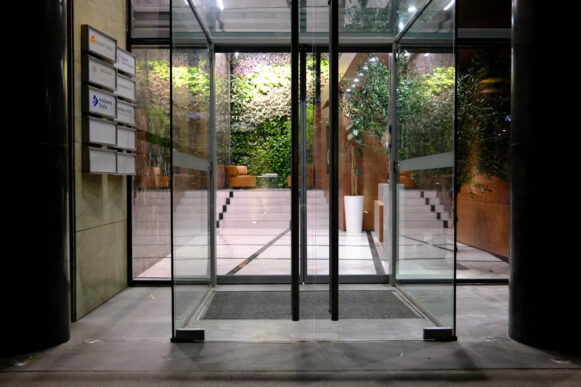 Glass entrance doors at a modern office illustrating access control and SAP S/4HANA access risk.