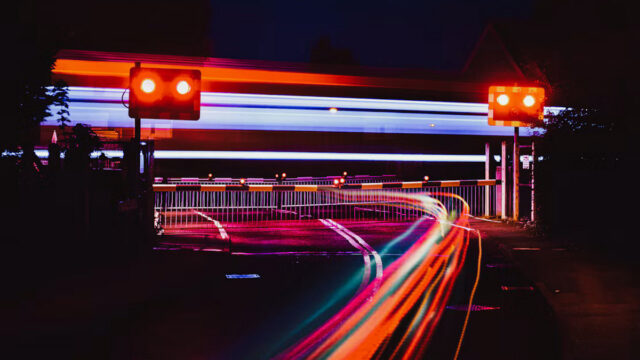 Traffic light on a pole at night above long-exposure light trails from passing cars, illustrating access controls for AI agents in SAP operations