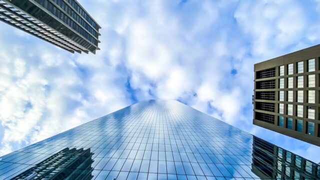 Blue glass office tower seen from below against a cloudy sky, illustrating the SAP Business AI Platform.