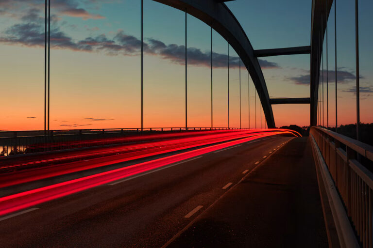 Long-exposure light trails crossing a bridge at sunrise, illustrating Neptune DXP25 connecting AI to SAP systems.